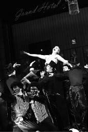 „Grand Hotel“ nach Vicki Baums Roman „Menschen im Hotel“ am Bayerischen Staatstheater am Gärtnerplatz. Milica Jovanovic als Flämmchen, Tom Schimon als Jimmy 1, Vladimir Maxim Korneev als Jimmy 2 und ein Musical-Gastensemble. Foto: Hermann Posch